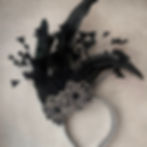 Tiara de Carnaval luxuosa na cor preta, vista de cima sobre um fundo neutro. A peça possui um arranjo assimétrico de plumas