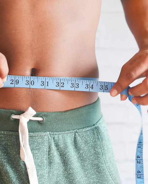 Man measuring waist after men’s weight loss and peptide therapy at Bloom Aesthetics & Wellness in Lakewood Ranch, Florida