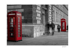 Cabines téléphoniques rouge londoniennes, icônes britanniques. La photographie presque totalement en noir et blanc ne laisse que le rouge dominer l'image. Quant aux personnages, ils apparaissent dans un flou de bougé venant donner du mouvement.