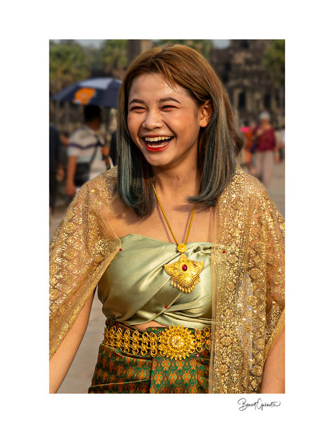 A radiant smile from a young woman in her traditional clothing at the Angkor Wat temple in Cambodia