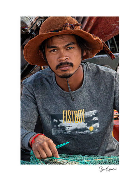 Pêcheur réparant ses filets près de la ville de Kep au Cambodge