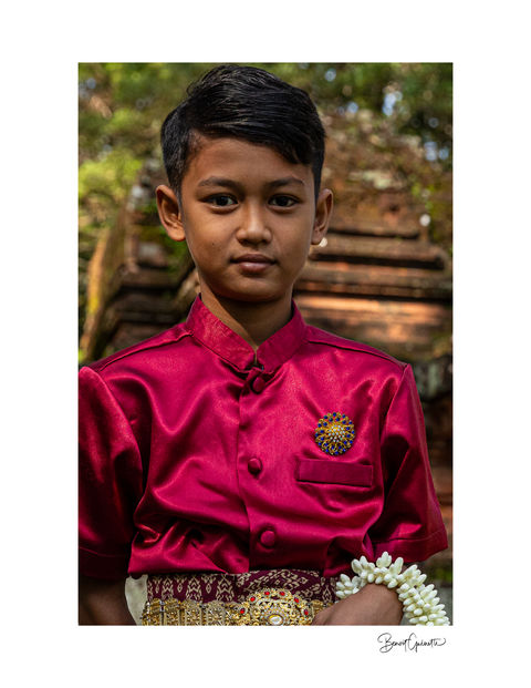 Young man dressed in traditional clothing posing near the Angkor site in Siem Reap, Cambodia