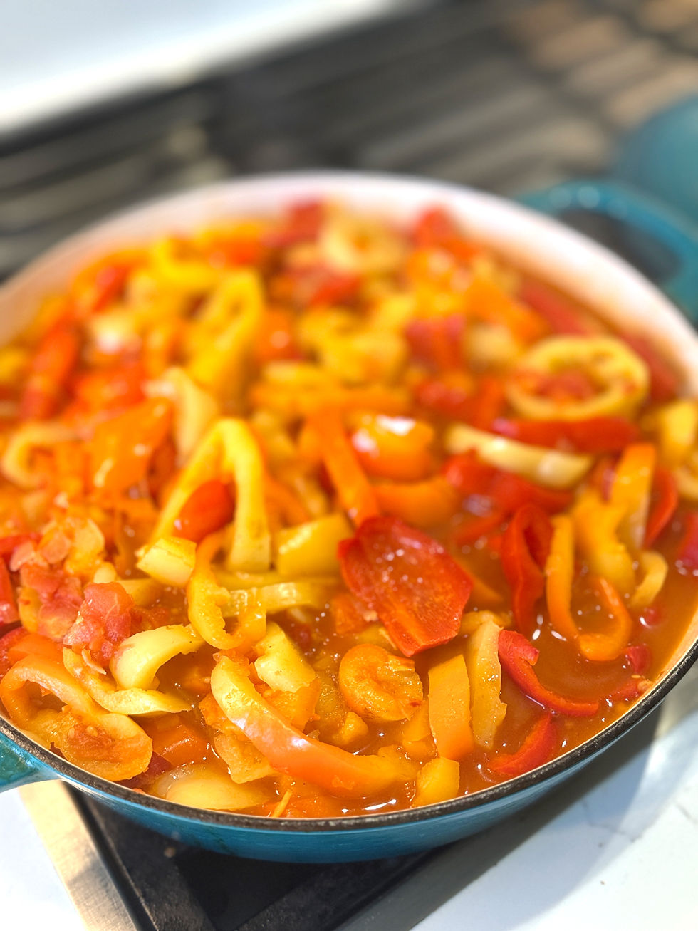 Traditional Hungarian lecsó cooking in a pan with sliced peppers, tomatoes, onions and paprika.