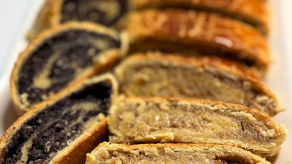 Sliced Hungarian beigli showing moist walnut and poppy seed fillings inside soft, tender dough.