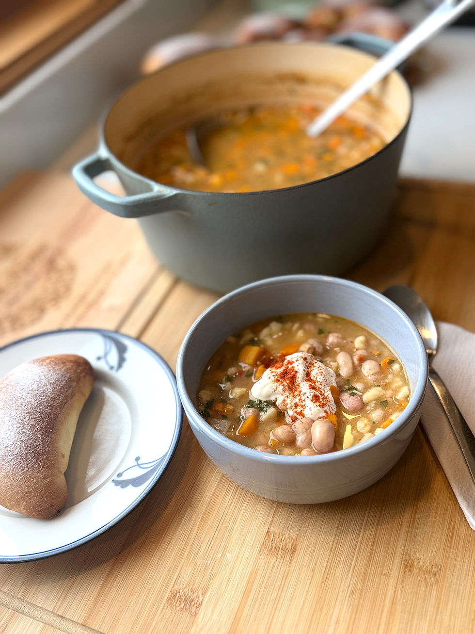 Hungarian fejtett bableves with fresh shelled beans, root vegetables, homemade csipetke and sour cream, served with bread.