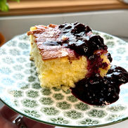 Traditional Hungarian rizskoch baked rice pudding served with powdered sugar and dark berry preserves.