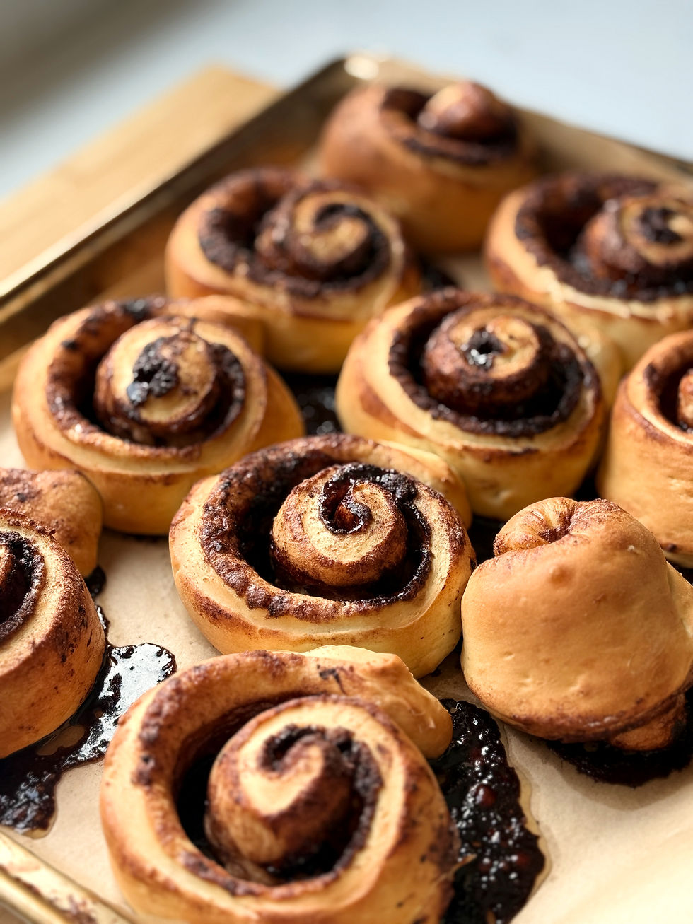 Homemade Hungarian kakaós csiga chocolate rolls freshly baked on a parchment-lined baking tray.