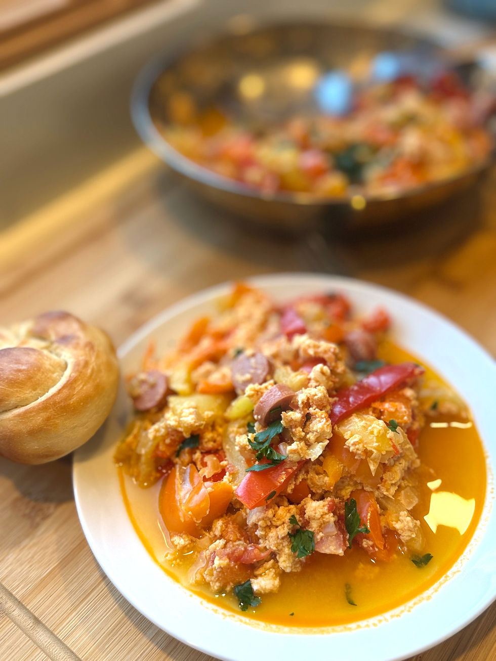 Hungarian lecsó with eggs, peppers, tomatoes and virsli served with fresh bread.