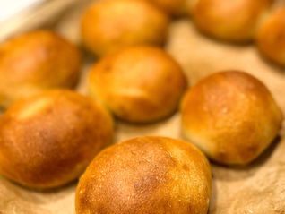 Homemade Hungarian water rolls, or vizes zsemle, freshly baked until golden brown on a parchment-lined baking tray.