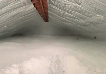 Attic with perfectly installed blown-in insulation and a reflective solar radiant barrier, fully insulated for energy efficie