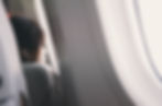 Sonic Branding in the sky with a person on a plane, gazing out the window with headphones on.