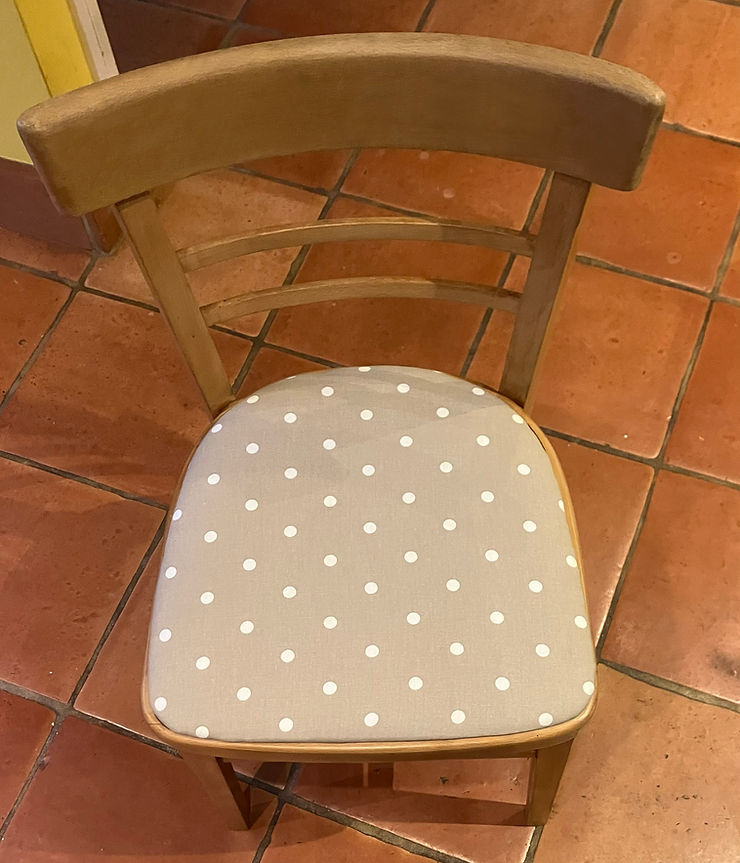 Close-up view of a vintage wooden chair with freshly reupholstered fabric seat