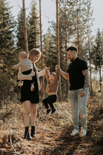 äiti-ja-isä-keinuttavat-lasta-ksäsitä-lapsi-nauraa