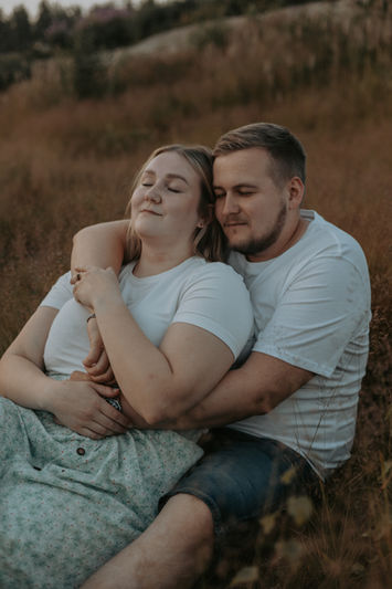 mies ja nainen halaavat toisiaan niityllä