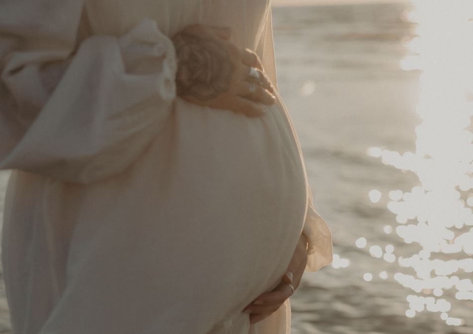 valkoinen-mekko-raskausvatsa-kädet-meri