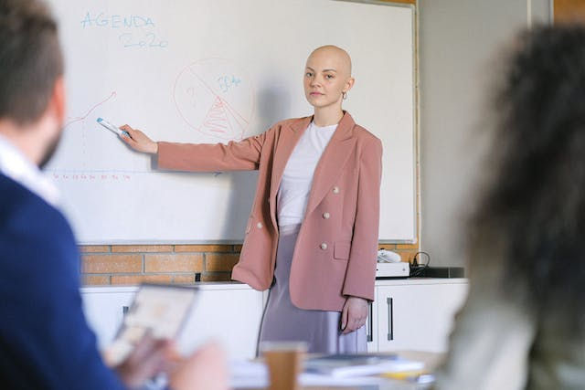 A woman teaching something using a whiteboard