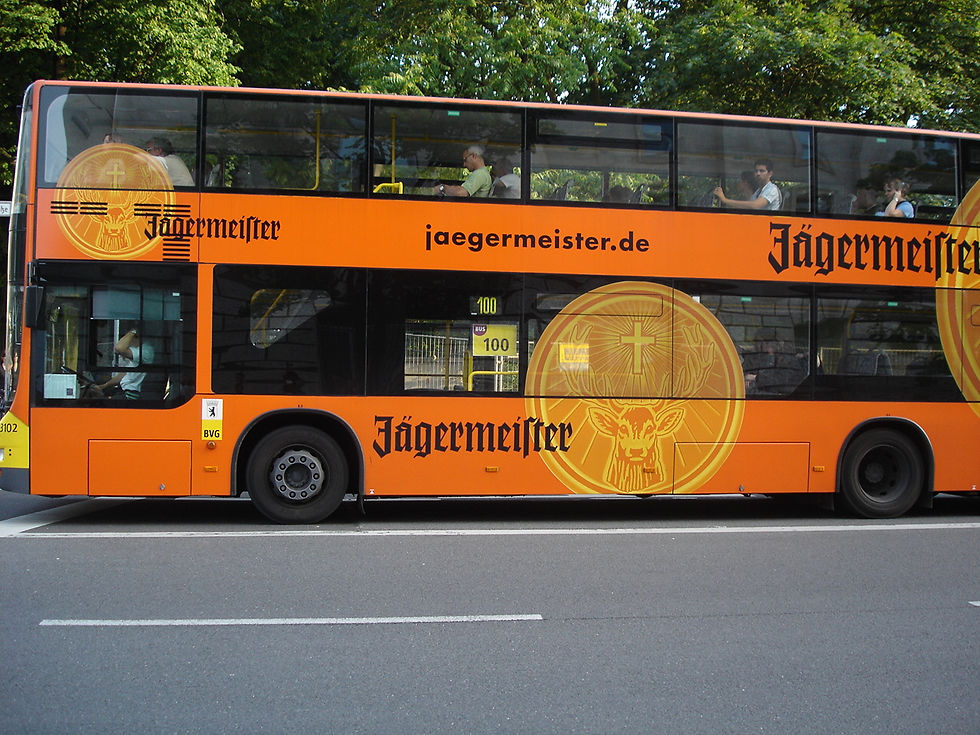 jagermeister written on an orange bus on a street