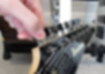 A hand tuning the pegs of a guitar