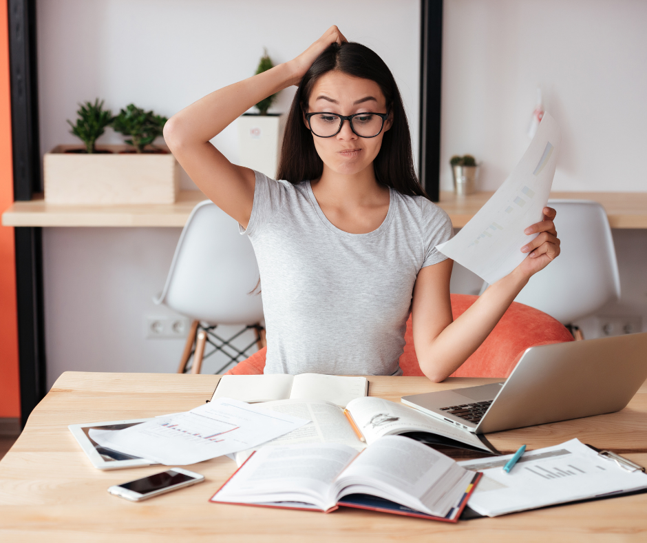 woman disorganized with paperwork and laptop