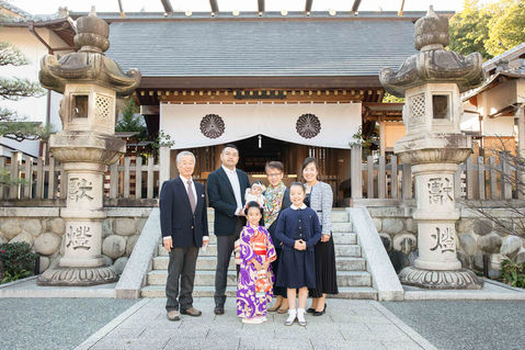 神社の前で並ぶ家族