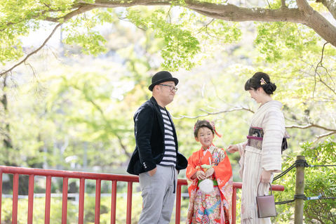 七五三の着物を着て談笑している女の子と夫婦