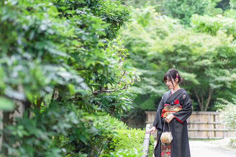 公園で手すりに手を添える振り袖を着た女性