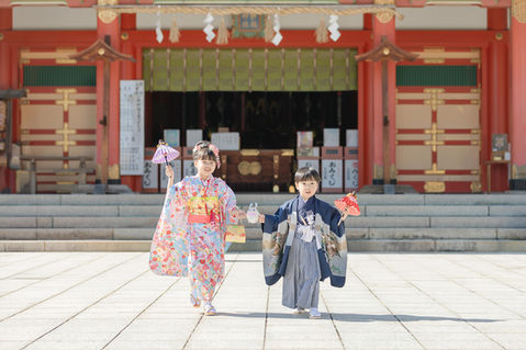 手を人形を挟んで手を繋いで七五三の着物を着た兄弟