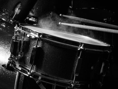 Snare drum in stage lighting, symbolizing the choice between online and in-person drum lessons