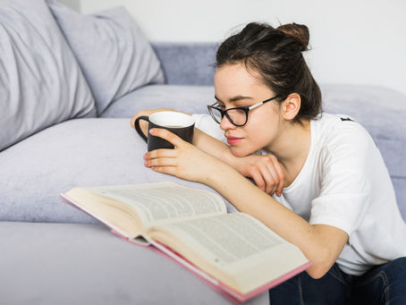A woman reading a book on the couch | Image Source: Magnific