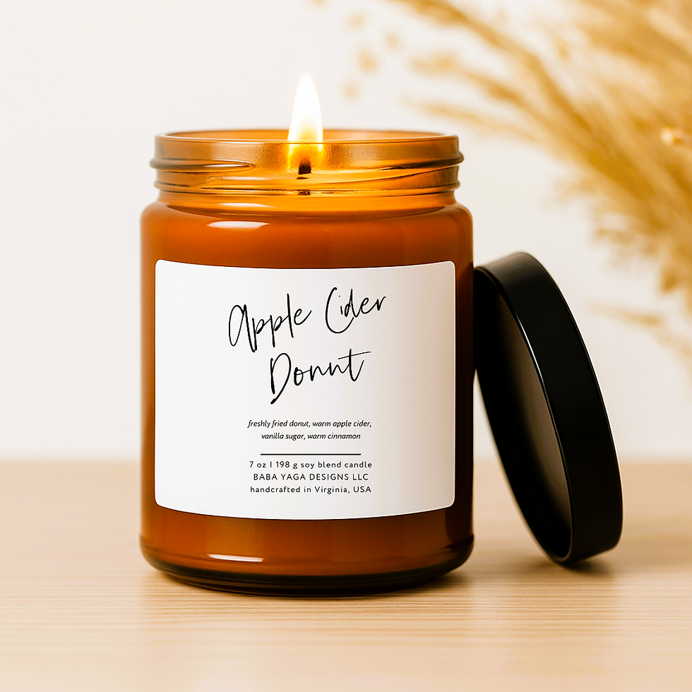 Thumbnail: Amber jar candle with black lid and white label, standing on light brown surface with dried botanicals and white background 