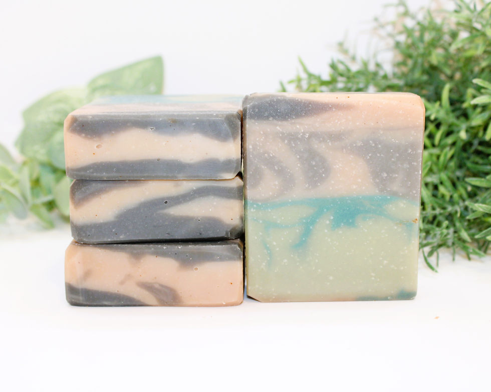 Stacked soap bars, photographed on a white surface with greenery.