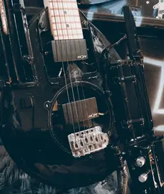 Ein einzigartiges Kunstwerk: Eine handgefertigte Gitarre, geschaffen aus recycelten Rasenmäher-Teilen. Dieses faszinierende Instrument vereint handwerkliches Geschick mit kreativer Vision, während es auf nachhaltige Weise eine unkonventionelle Ästhetik einfängt. Entdecken Sie die innovative Fusion von Kunst und Handwerk in diesem Bild einer selbstgebauten Gitarre, die aus recycelten Rasenmäher-Teilen eine einzigartige musikalische Erzählung formt