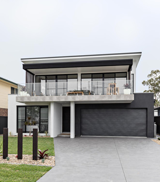 Contemporary beachfront home with glass balcony,  landscaped entry and double garage
