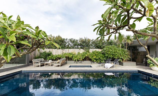 Heated pool and spa surrounded by tropical greenery at Sundara Beach House