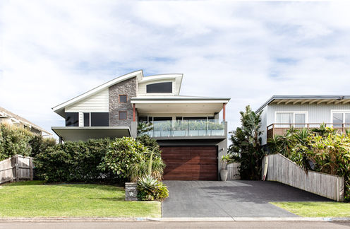 Front facade of Sundara Beach House with landscaped gardens and modern architecture