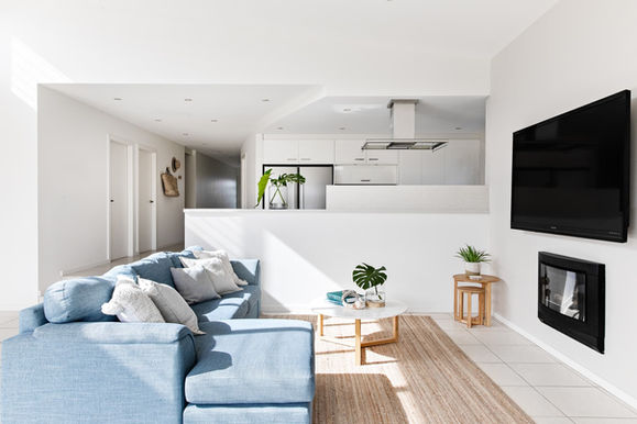 Open-plan living and kitchen area with coastal furnishings at Sundara Beach House