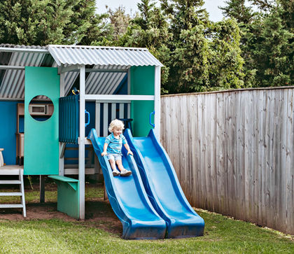 Child playing in backyard cubby house at Sundara Beach House