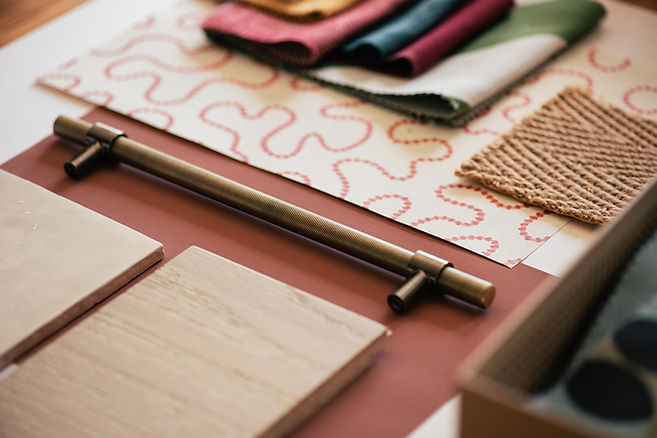 A close up shot of a mood board showing paint colours, fabric and wallpaper.