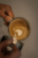 Barista pouring latte art into a freshly made coffee at Lake Street Coffee