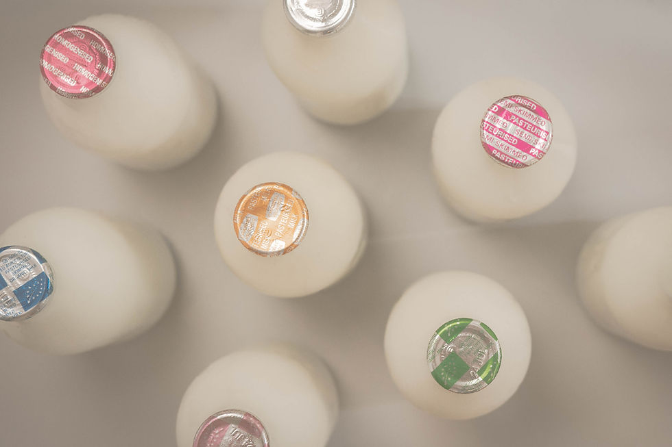 Overhead view of milk bottles with foil tops.