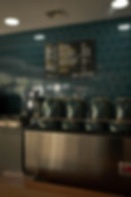Row of takeaway coffee cups lined up on the counter at Lake Street Coffee, ready for busy morning service.
