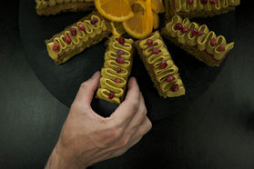 Chef placing pistachio and pomegranate canapés on serving board — Fourteen Lakes Catering, Milton Keynes