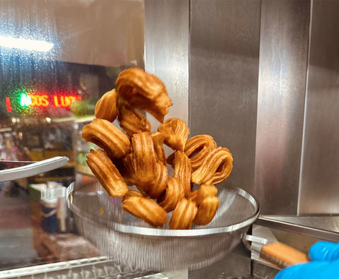 La churroteka churro bites being tossed in bow
