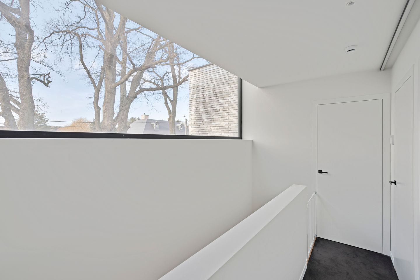Modern interieur met een rustgevende sfeer, gekenmerkt door witte tinten en houten accenten die warmte en elegantie toevoegen aan de ruimte