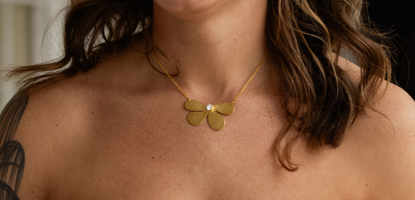 Woman wearing the Menzaman Aura Necklace and earrings from the Blossom Collection