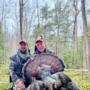 Two men with Turkey after a hunt.