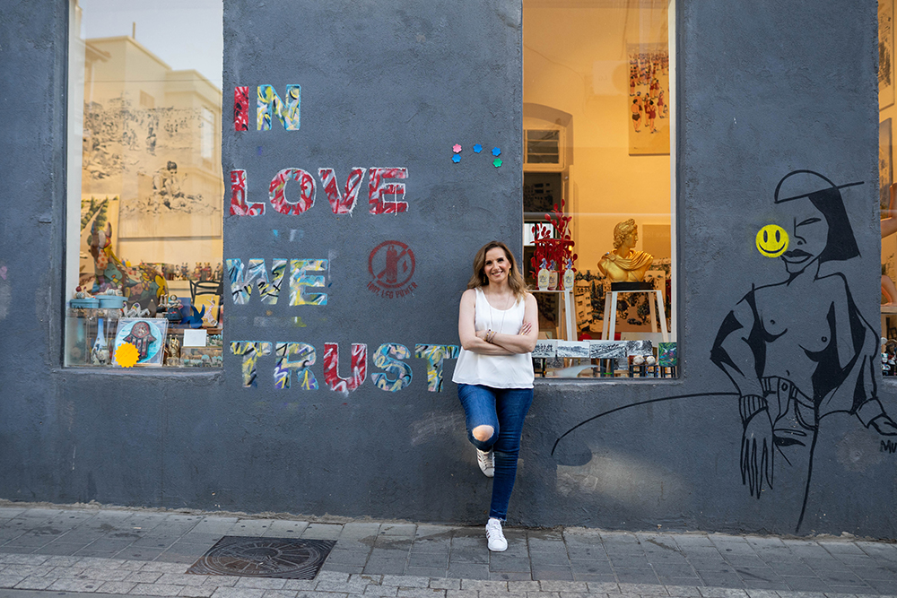 נטע נשענת על קיר עם גרפיטי