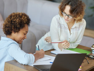 A one-on-one tutoring session takes place with a K-12 age child