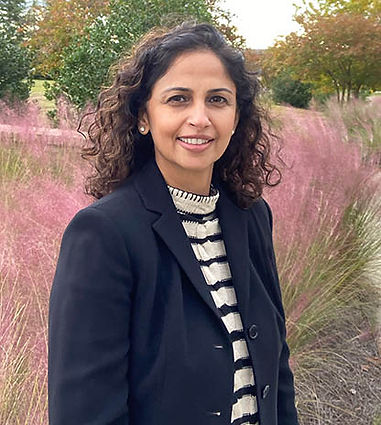 Dr. Alam posing outside in a navy balzer