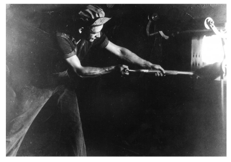 man shovelling coal in to burner